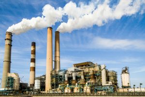 pexels-photo-247763-247763 A large industrial power plant with smokestacks emitting smoke under a blue sky, symbolizing pollution.